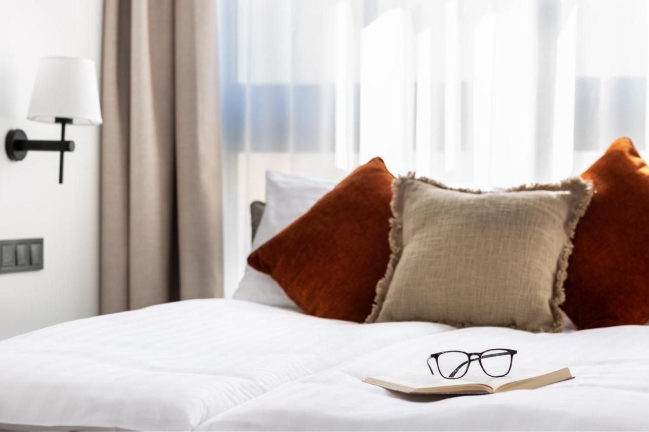H11 Aparthotel Cracovia Esterno foto A bed with cushions